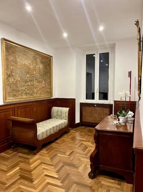 Camera elegante di Domus Giovanna B&B Roma, con arredi in legno, pavimento a spina di pesce e arredamento classico