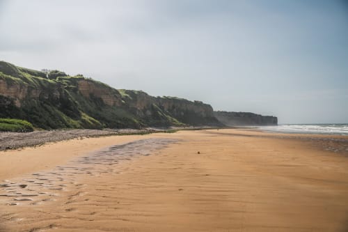 Golden sandy beach with dramatic cliffs in Normandy, France near Skol In hotel