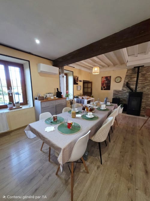 Esszimmer im La Maison de la Colline BnB in Vers, Frankreich mit gedecktem Tisch und rustikalen Balken