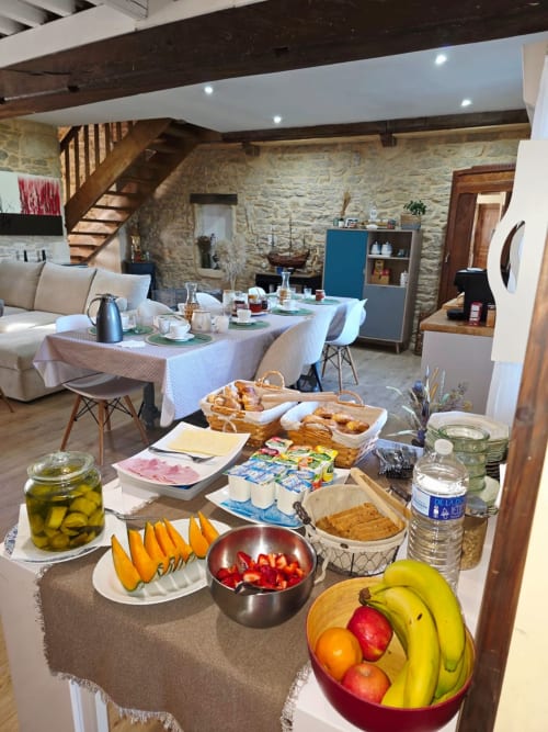 Frühstücksbuffet im La Maison de la Colline B&B in Vers, Frankreich, mit frischen Früchten, Gebäck und Gedeck