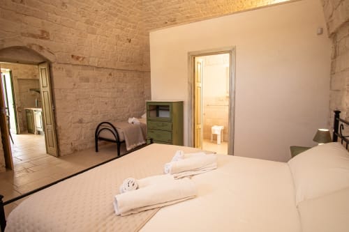 Camera dell'hotel Trulli Life a Bari con letti gemelli, muri in pietra e bagno en-suite