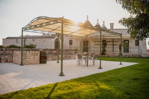 Terrazza esterna dell'hotel Trulli Life a Ostuni con pergolato, zona lounge e architettura tradizionale in pietra