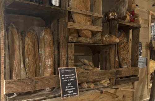 Rustic wooden bread display with fresh baguettes at Chez Francine bakery, Notre Dame de Bellecombe