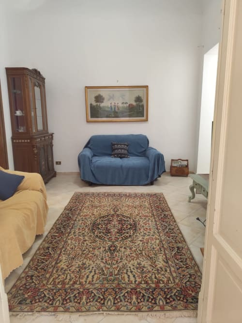 Camera da letto Mappamondi B&B a Venezia con divano blu, letto giallo, tappeto ornamentale e mobili d'epoca