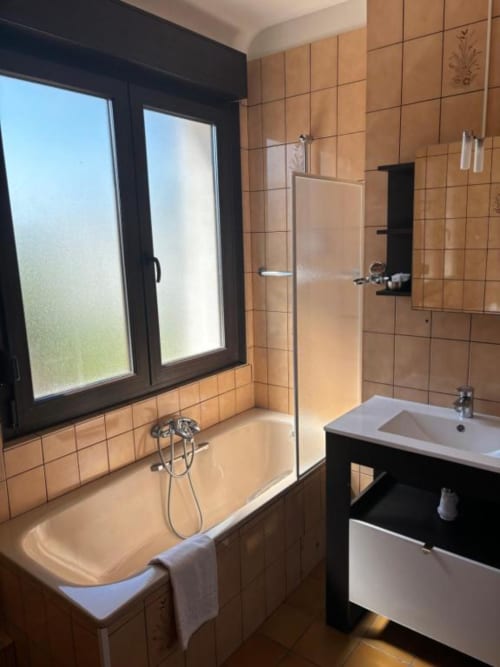 Modern bathroom in Family Room at Hôtel Restaurant Le S'Y with bathtub, shower, sink, tiled walls and garden view window