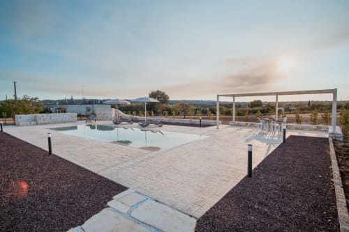 Area piscina sulla terrazza del Trulli Life hotel a Ostuni con lettini, pergola e vista sulla campagna