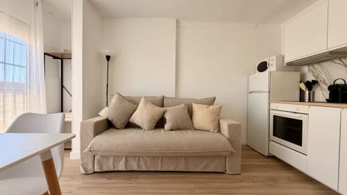 Moderno apartamento estudio en Holidays Costa Brava con sofá beige, cocina y suelos de madera en Girona
