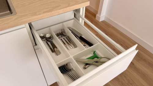 Cajón de cocina organizado con divisor de utensilios que contiene cubertería, cuchillos y herramientas de cocina en Holidays Costa Brava