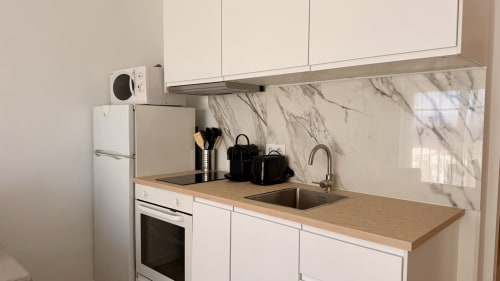 Cocina moderna del apartamento Karina 6C en Holidays Costa Brava con muebles blancos, backsplash de mármol y vistas al río