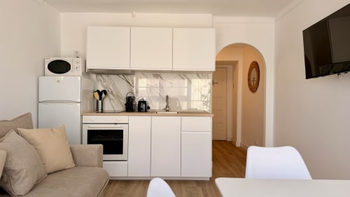 Moderna cocina y sala de estar del apartamento Karina 6C en Holidays Costa Brava, Girona con mueblería blanca y vistas al río