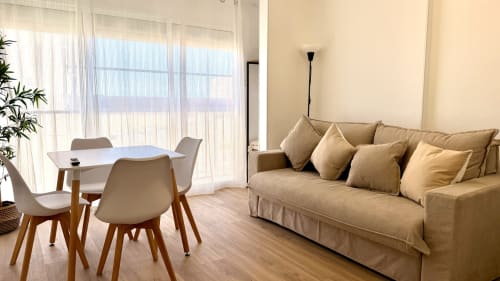Luminoso salón moderno con sofá beis, comedor y vistas al río en Holidays Costa Brava, Girona