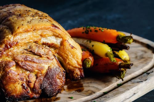 Roasted chicken with charred peppers on wooden board at The Kings Arms, Penrith