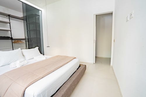 Camera moderna con letto matrimoniale, doccia in vetro e arredamento contemporaneo presso Zen Seaside Apartment a Genova