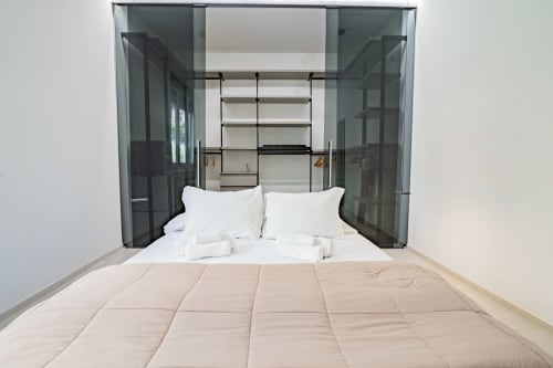 Camera da letto moderna nell'Appartamento Zen Seaside a Genova con biancheria bianca, tende trasparenti e arredamento minimalista