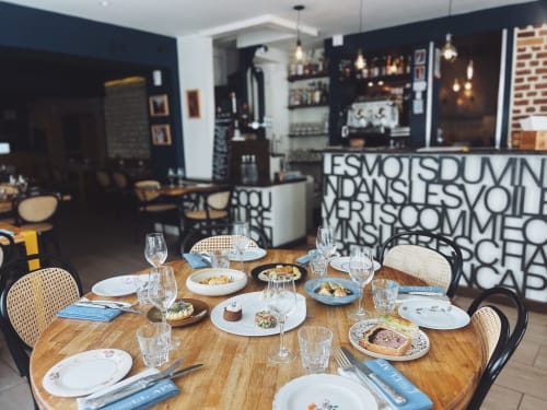 Elegant dining table setting at Clos Céleste in Étretat with plated dishes, glassware, and modern restaurant ambiance