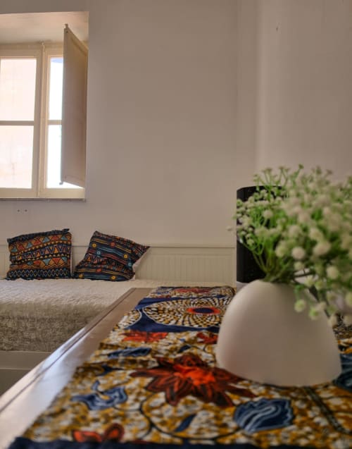 Camera luminosa del Bed & Breakfast Bright Venice a Mappamondi con letto, cuscini decorativi, fiori in vaso e finestra aperta