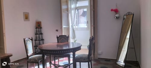 Elegante camera presso Mappamondi B&B a Venezia con tavolo da pranzo nero rotondo, sedie ornate e specchio in piedi