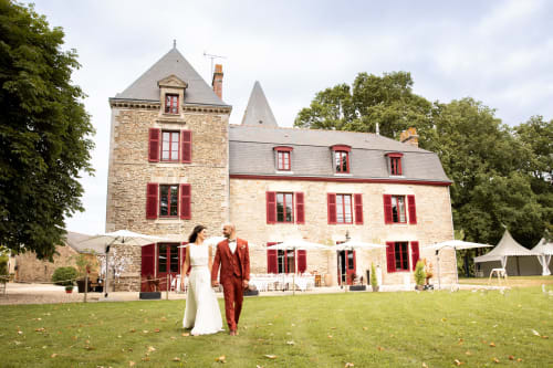 Les mariés marchent sur la pelouse du château de la Briandais à Missillac, France