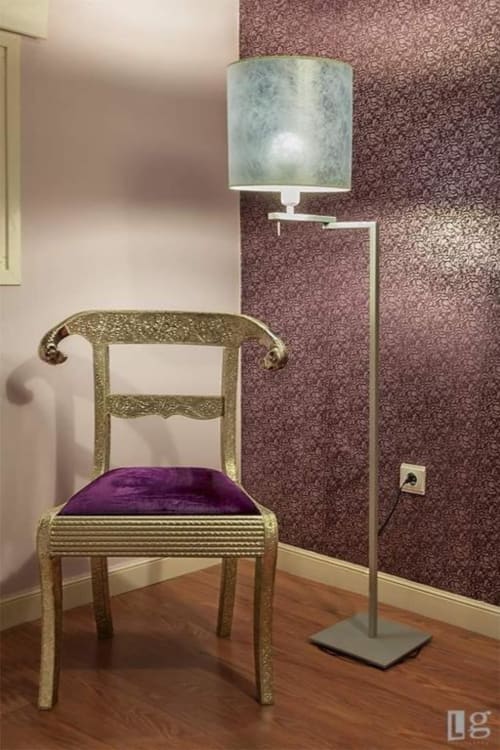 Elegant hotel room at Posada Torre del Milano featuring a gilded chair with purple cushion and modern floor lamp with sage