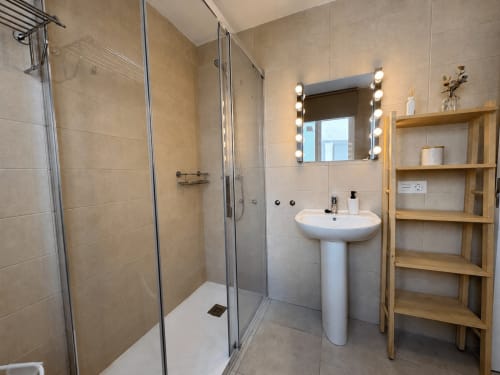Modern bathroom in Aroma de Azahar apartment at Living Sur, Sanlúcar de Barrameda, with shower, pedestal sink, vanity mirror