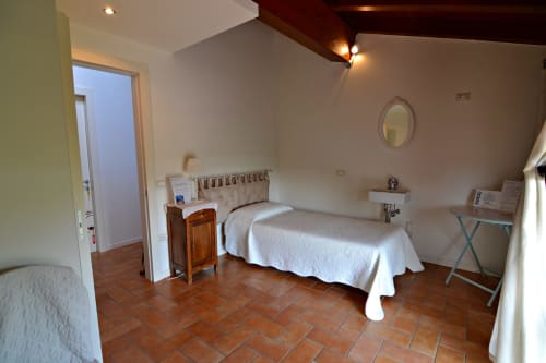 Camera Rosa della Corte delle Giuggiole B&B a Cologna Veneta con pavimenti in terracotta, biancheria bianca e vista sul giardino