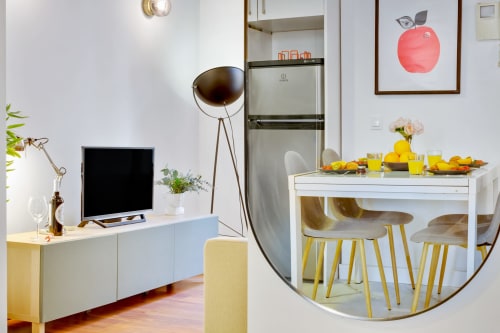 Modern Málaga apartment living area with dining table, kitchenette, TV, and stylish furnishings at Ayma Ollerías