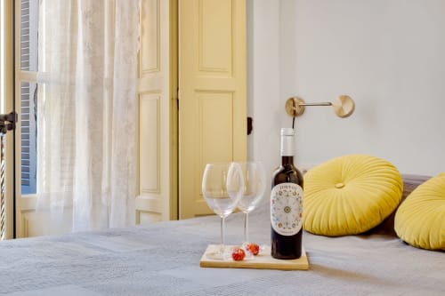 Elegant bedroom at Ayma Apartamento Ollerías in Málaga with wine, glasses, and yellow accent pillows