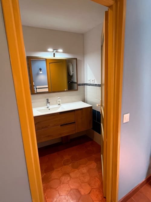 Salle de bain moderne du Jardin De Palme avec vasque en bois, miroir et carrelage en terre cuite