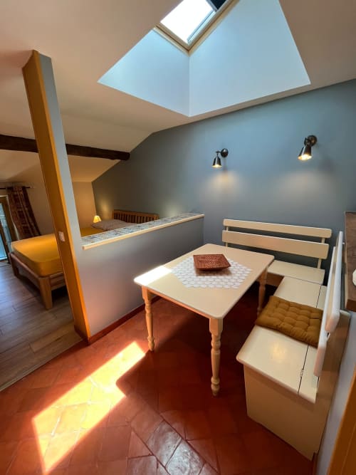 Appartement Le Cap au Jardin De Palme avec puits de lumière, table à manger, banquette et vue sur le jardin