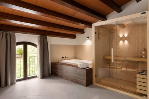 Suite spa lussuosa a Dimora Silva con sauna in legno, vasca da bagno, finestre ad arco e travi a vista