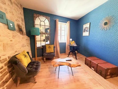 Habitación elegante en el Hôtel La Suite en Villeneuve-lès-Avignon con paredes estampadas azules, muebles vintage y madera