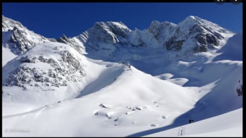 Sommets alpins enneigés et pentes immaculées de la station de ski Zoppas Courchevel sous un ciel bleu dégagé
