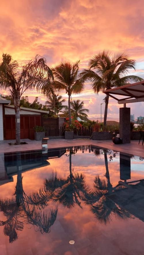 Coucher de soleil sur la piscine privée du gîte Les Balcons D'Oyster Pond à Saint-Martin avec palmiers et vue sur la mer