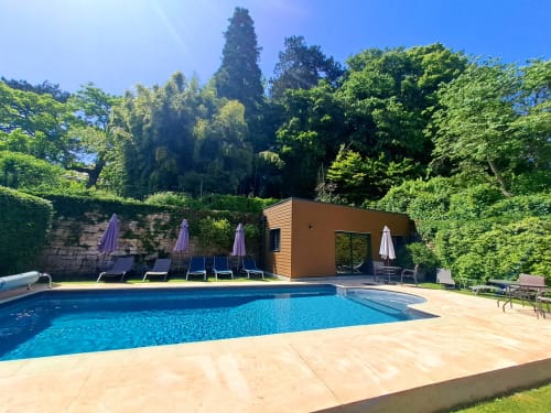 Luxueuse zone de piscine au Clos De La Gourmandiere avec transats, parasols et pavillon moderne