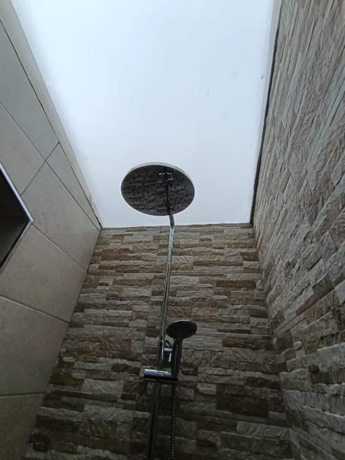 Moderno cabezal de ducha de lluvia en el baño de villa Sol, Alojamientos Las Mellis, Antequera, con paredes de azulejos de piedra