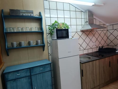 Cocina moderna en villa Sol de Alojamientos Las Mellis, Antequera, con estanterías azules, refrigerador, estufa y comedor