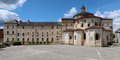 Le Pavillon Saint Martin Hotel courtyard in Souillac featuring historic stone buildings and Romanesque chapel