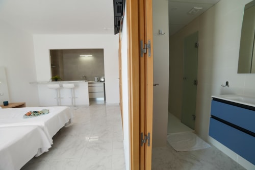Moderno estudio en Playa Sol, Es Canar, con cocina abierta, comedor y baño con lavabo azul