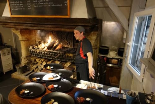Chef preparing plated dishes by fireplace at Clos Céleste, Etretat countryside B&B