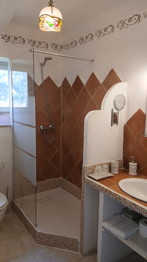 Salle de bain moderne au gîte La Ribeyrette : carrelage losange marron, douche à l'italienne, lavabo blanc, décoration