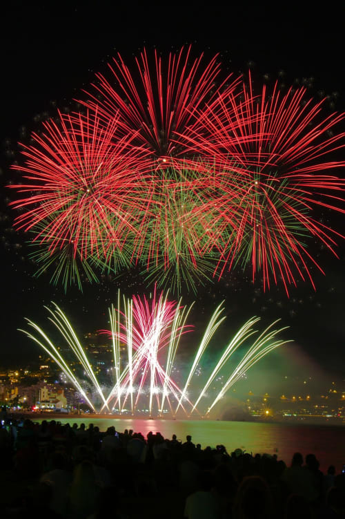 Des feux d'artifice rouges et verts éclatent au-dessus de l'eau près de Meolans-Revel, célébration à la maison d'hôtes Les Méans