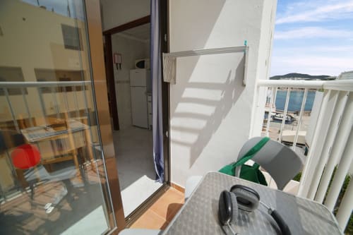 Vista del balcón en Apartamentos Playa Sol en Es Canar con vistas al mar, tendedero y sierra de fondo