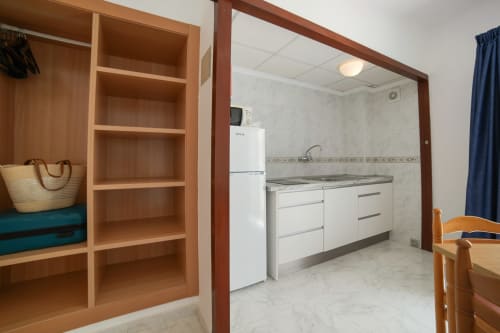 Cocina y sala de estar estándar en Apartamentos Playa Sol, Es Canar con electrodomésticos blancos y mobiliario de madera
