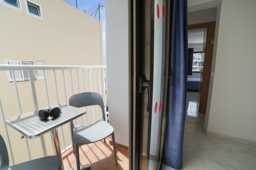 Balcón del Apartamentos Playa Sol en Es Canar con mesa, silla y vistas a la montaña
