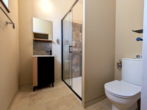 Salle de bain moderne du gîte Domaine Alga à Bourg-Charente avec douche à l'italienne, vasque et toilettes
