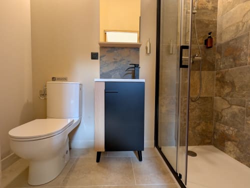 Salle de bain moderne du gîte Domaine Alga avec toilettes, lavabo et douche à l'italienne carrelée