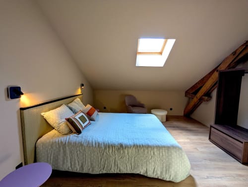 Chambre lumineuse mansardée au gîte Domaine Alga à Bourg-Charente avec lucarne, lit, poutres et coin détente
