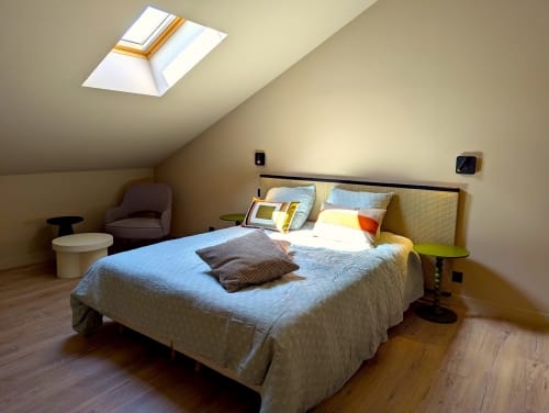 Chambre lumineuse sous les combles au Domaine Alga avec lit queen, puits de lumière, fauteuil et équipements modernes à Bourg-Charente