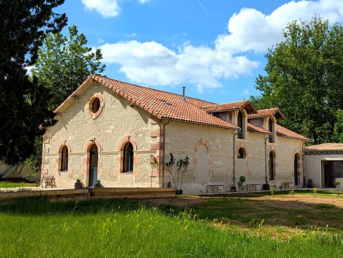 Maison en pierre au Domaine Alga à Bourg-Charente avec toit en terre cuite et fenêtres en arc