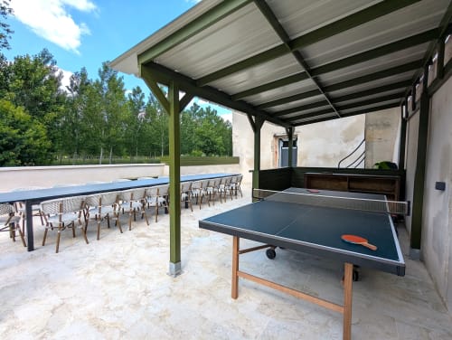 Terrasse couverte extérieure du Domaine Alga avec table de ping-pong, espace repas et chaises longues au bord de la piscine